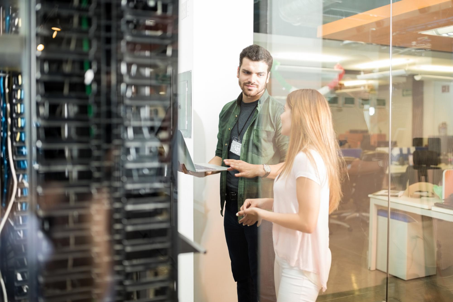 one girl and boy standing near computer servers